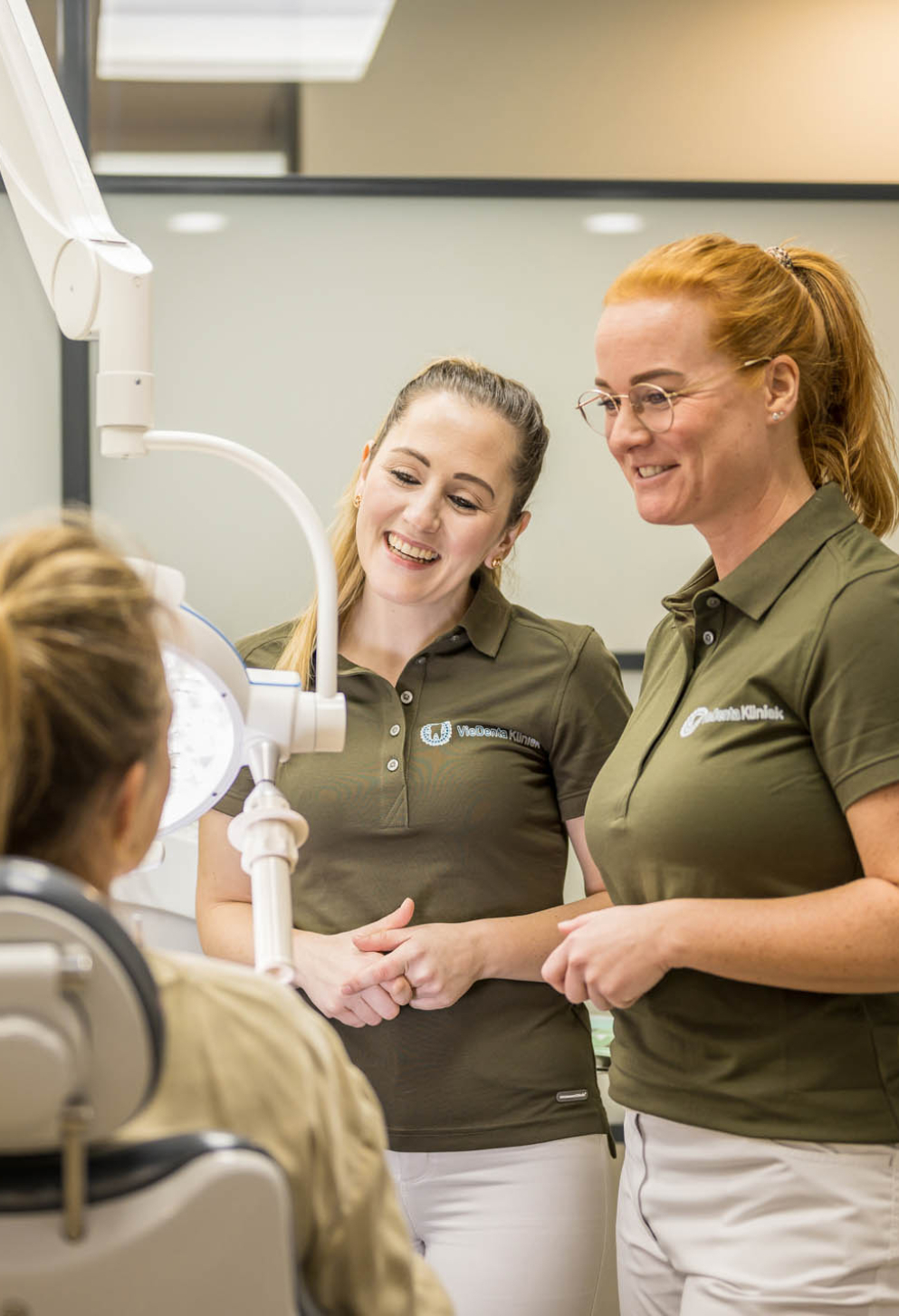 Twee tandartsassistentes met patient