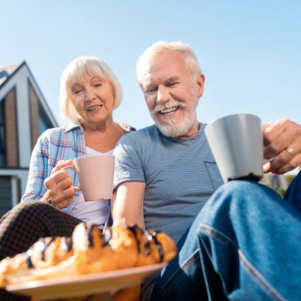 Ouder stel dat geniet van kop koffie en gebak