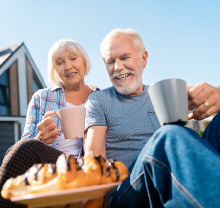 Ouder stel dat geniet van kop koffie en gebak