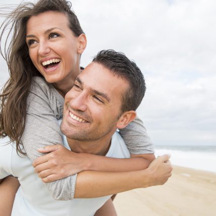 Glimlach jongen en meisje op het strand